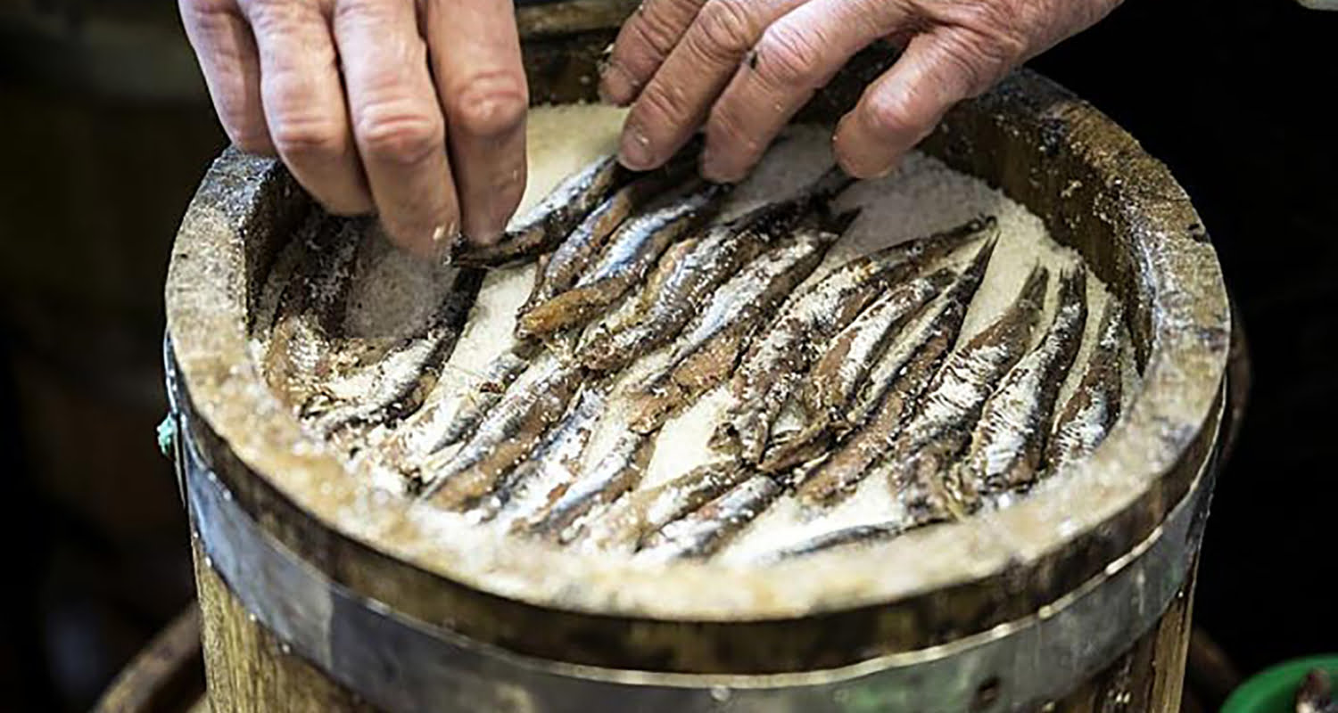 Er wordt om en om een laag ansjovis en zout opgestapeld
